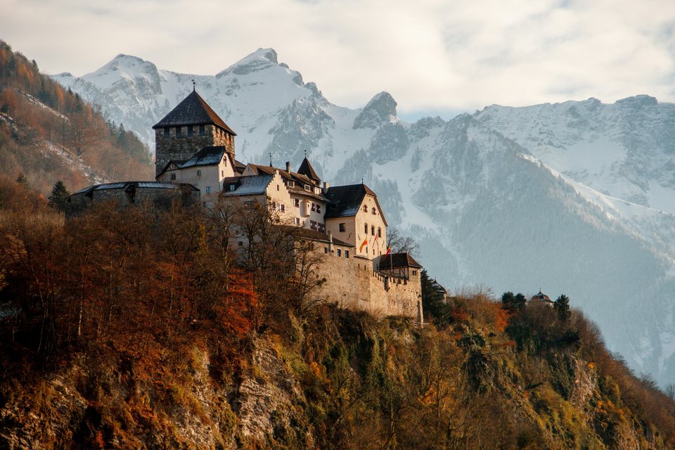 Schloss Vaduz in Liechtenstein vor schneebedeckten Bergen.